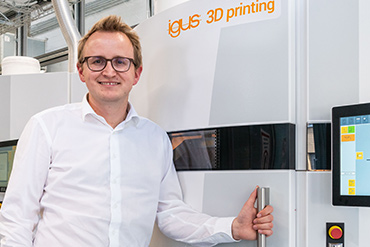Tom Krause foran en SLS 3D printer